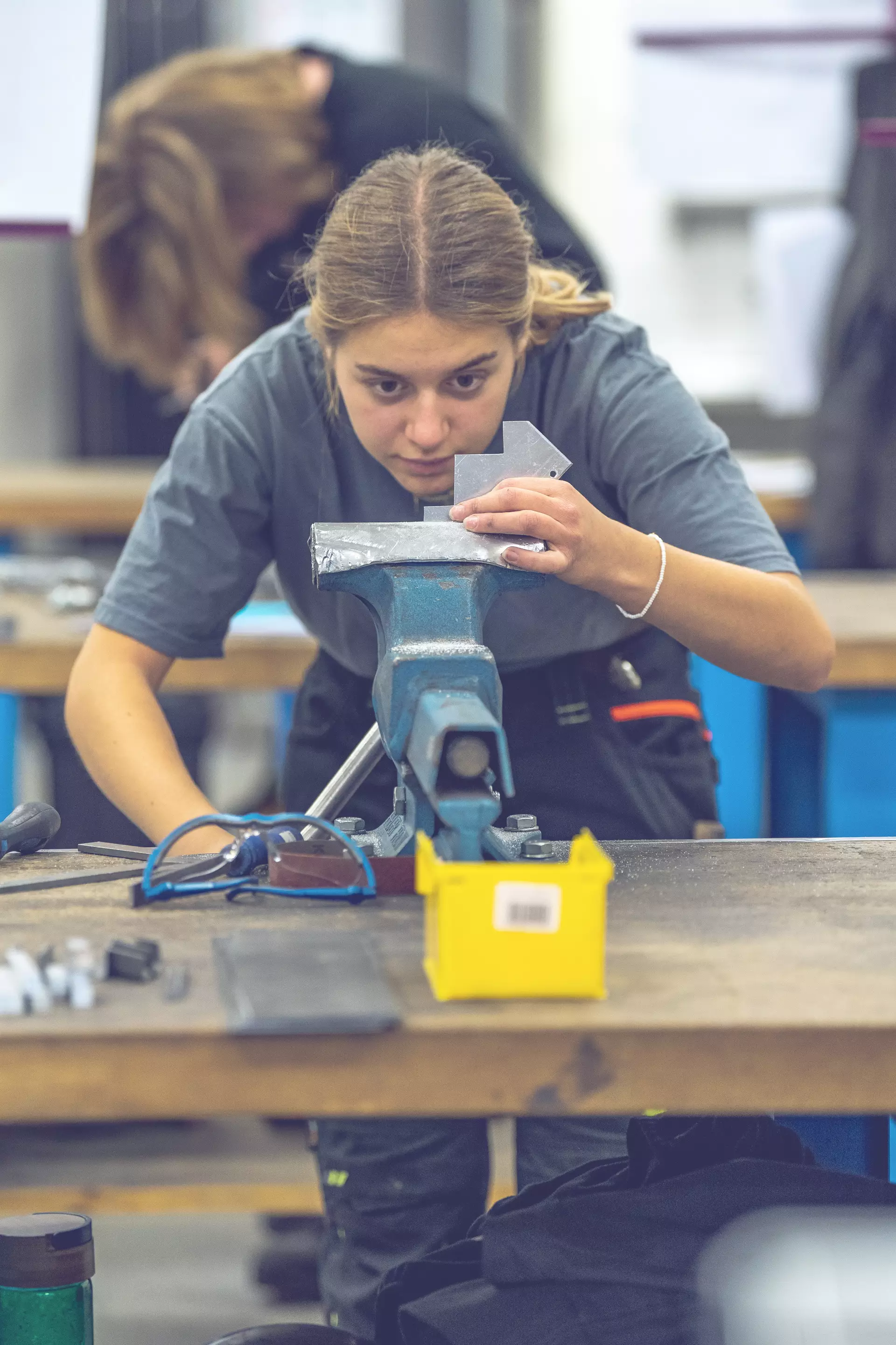 Apprentie constructeur métallique penchée sur la fabrication d'une pièce