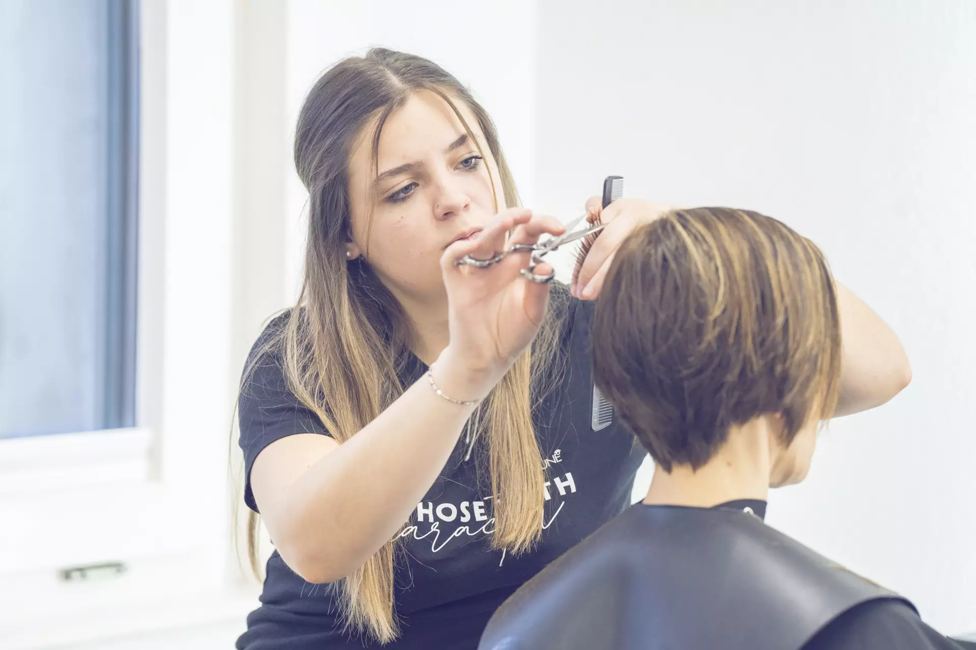 Coiffeuse faisant une coupe à une cliente