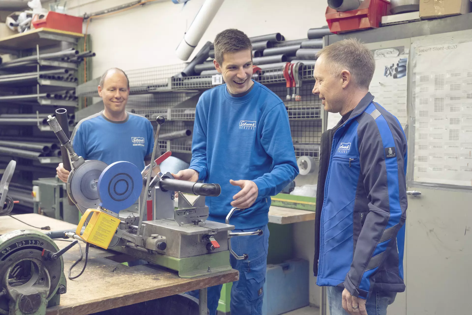 Apprenti chauffage sanitaire et ses formateurs en train de discuter autour de son poste de travail