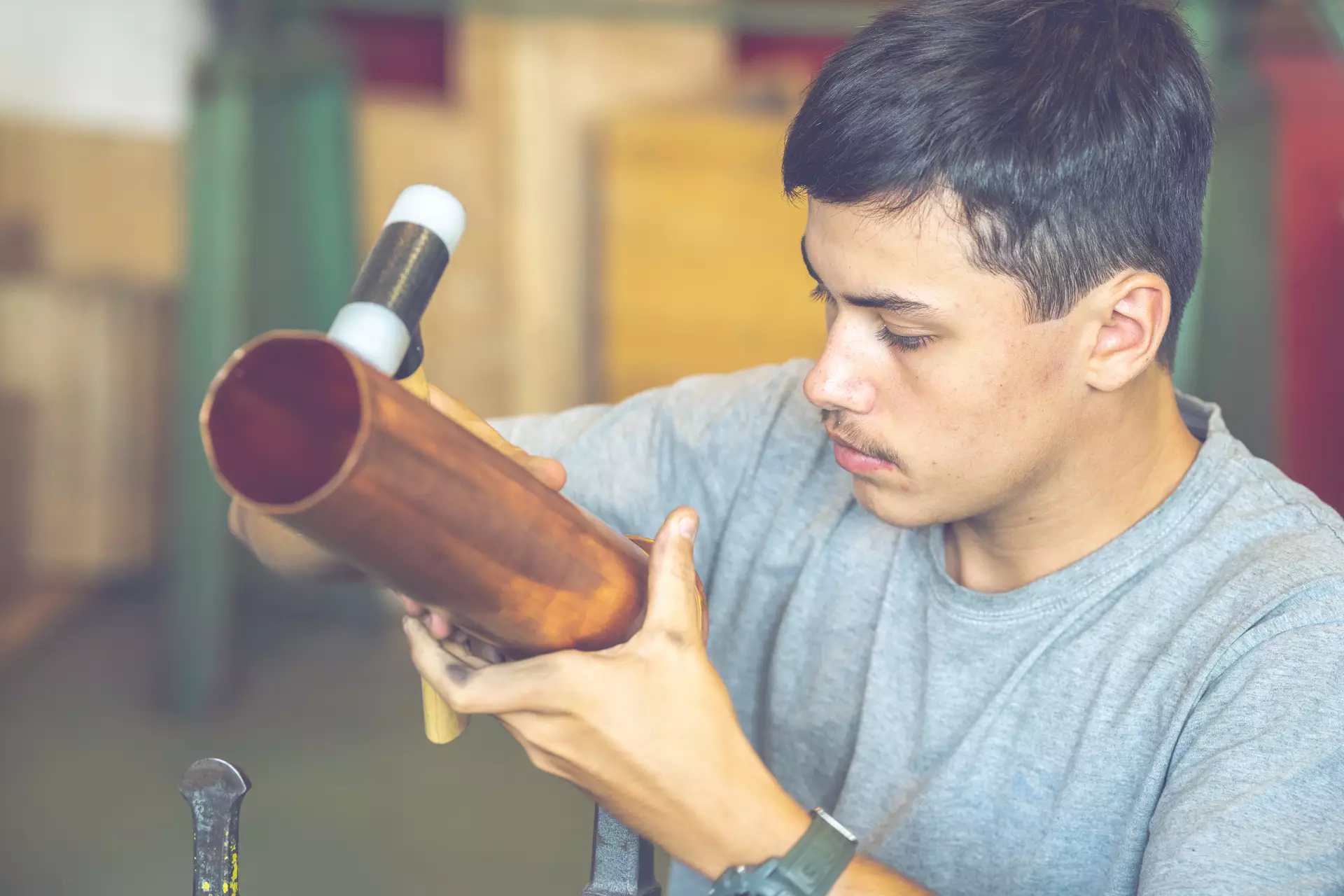 Apprenti ferblantier façonnant un tube