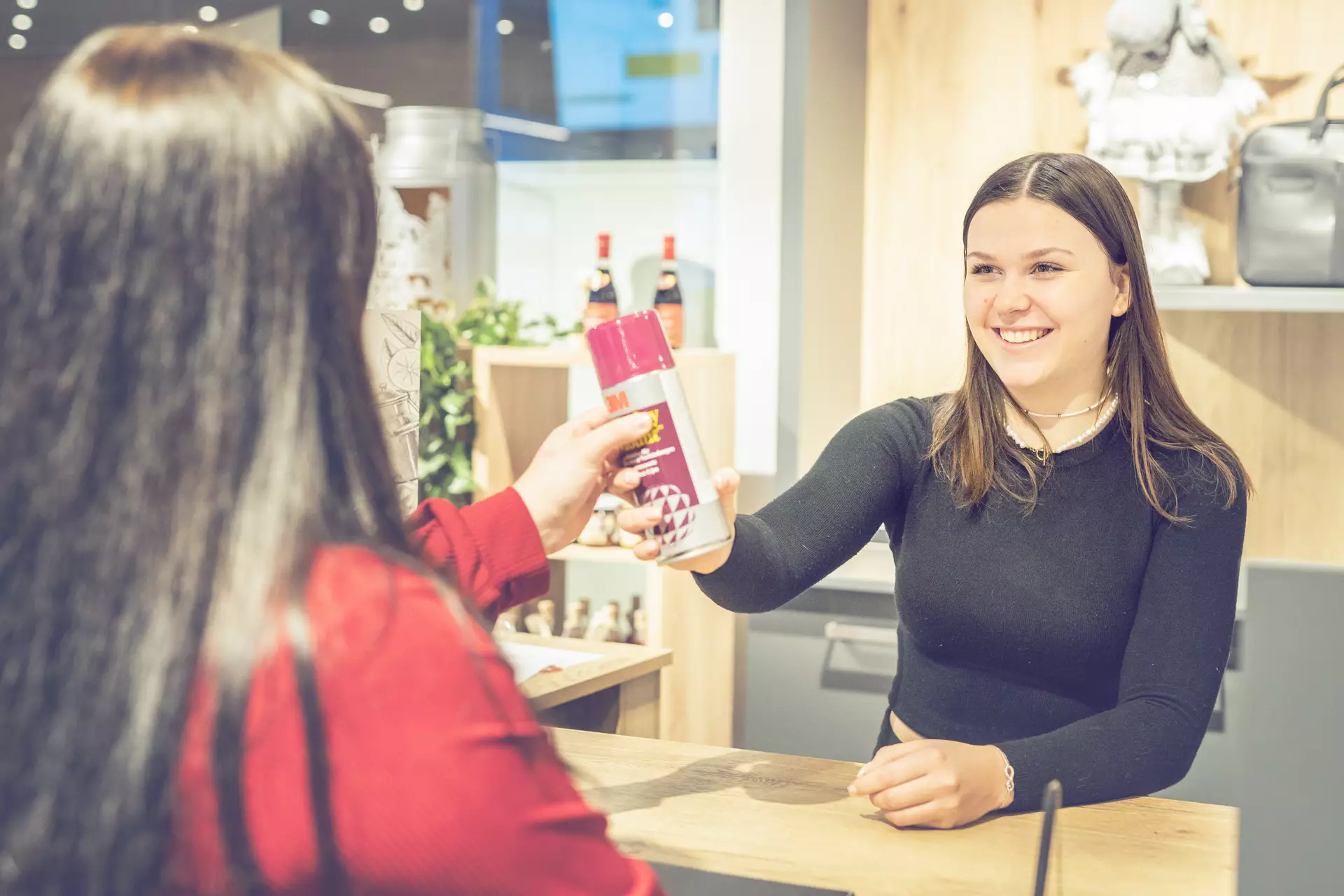 apprentie employée de commerce vendant un produit à une cliente
