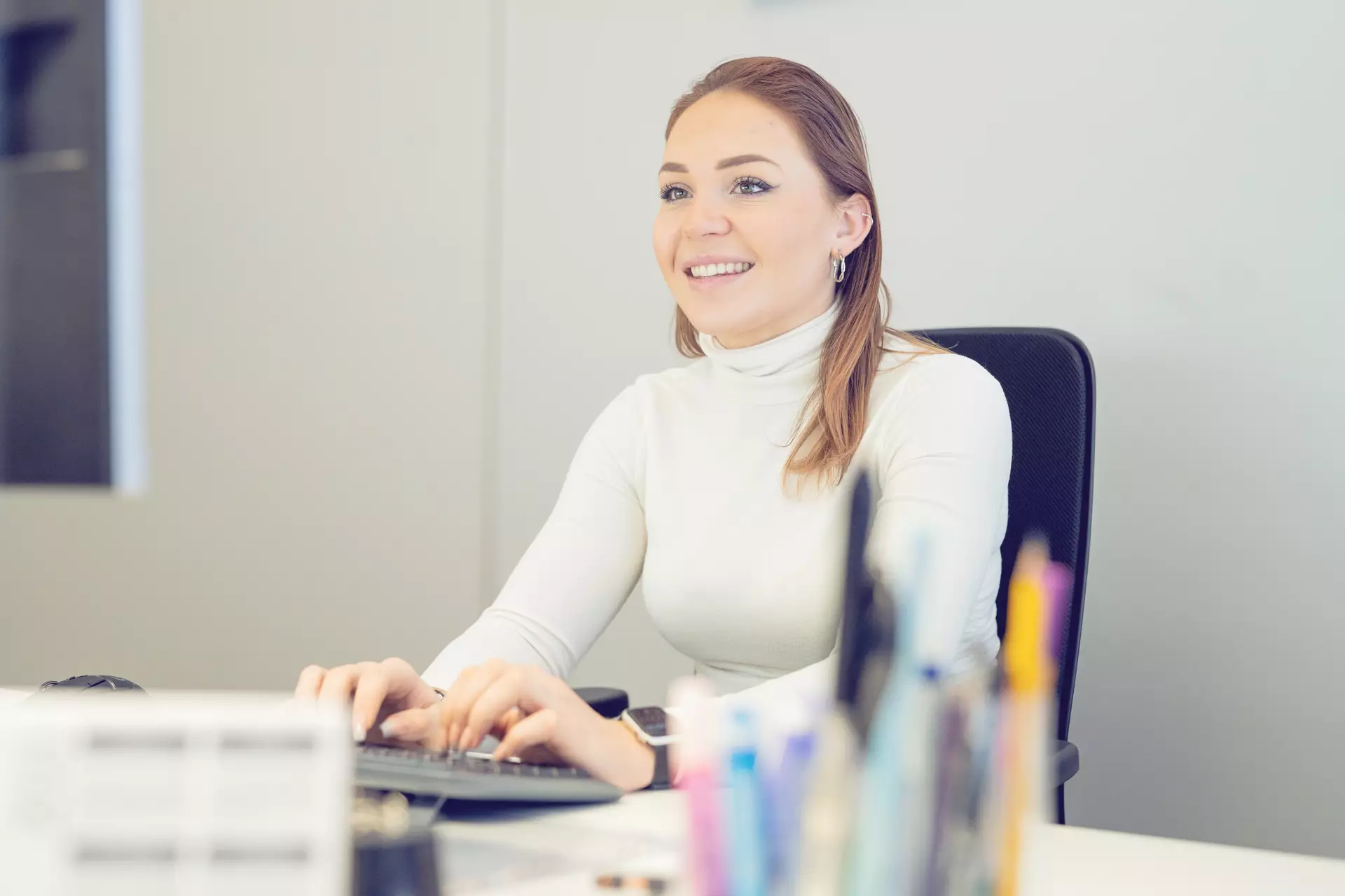 Apprentie employée de commerce tapant à l'ordinateur