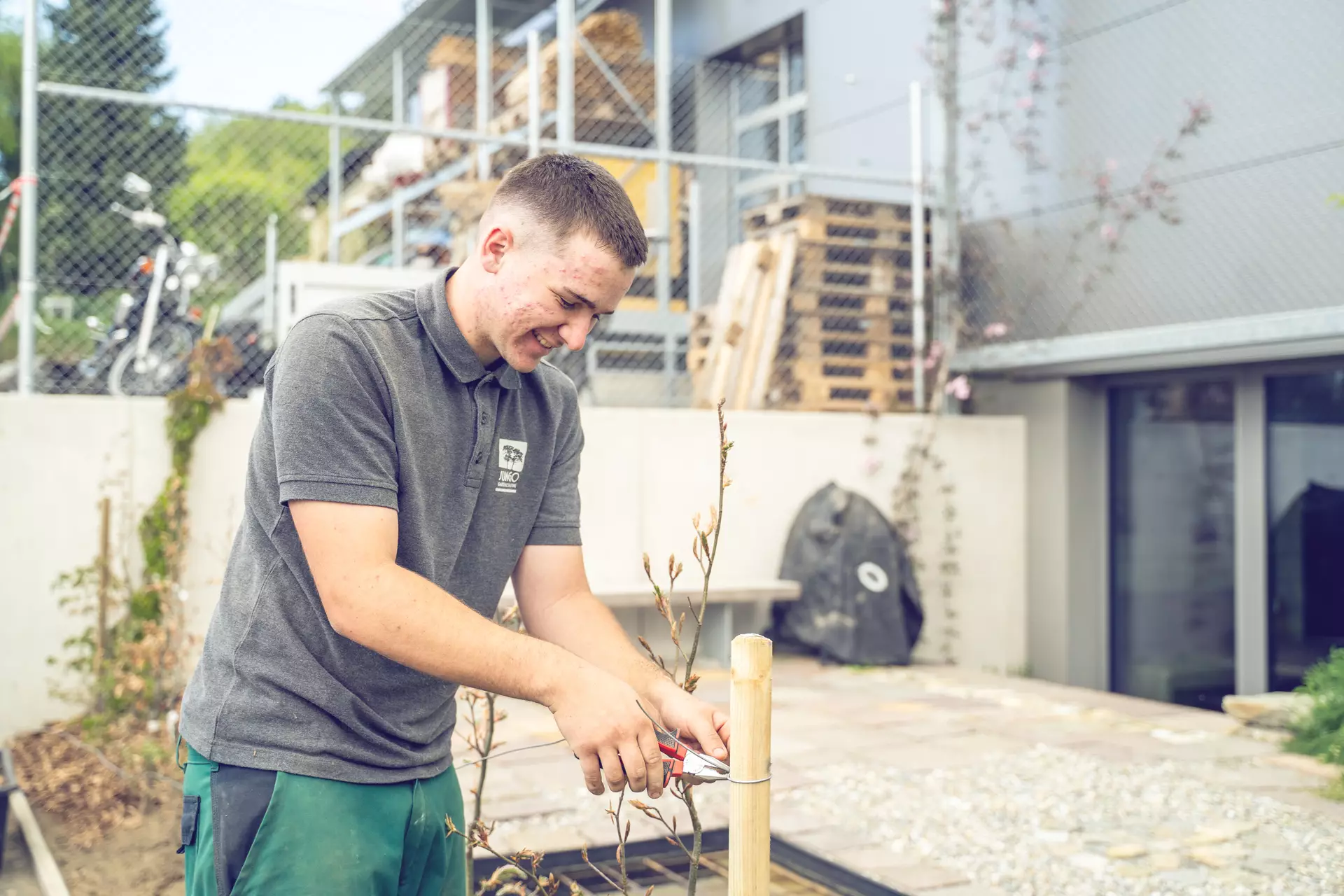 Apprenti paysagiste en train de fixer une barrière