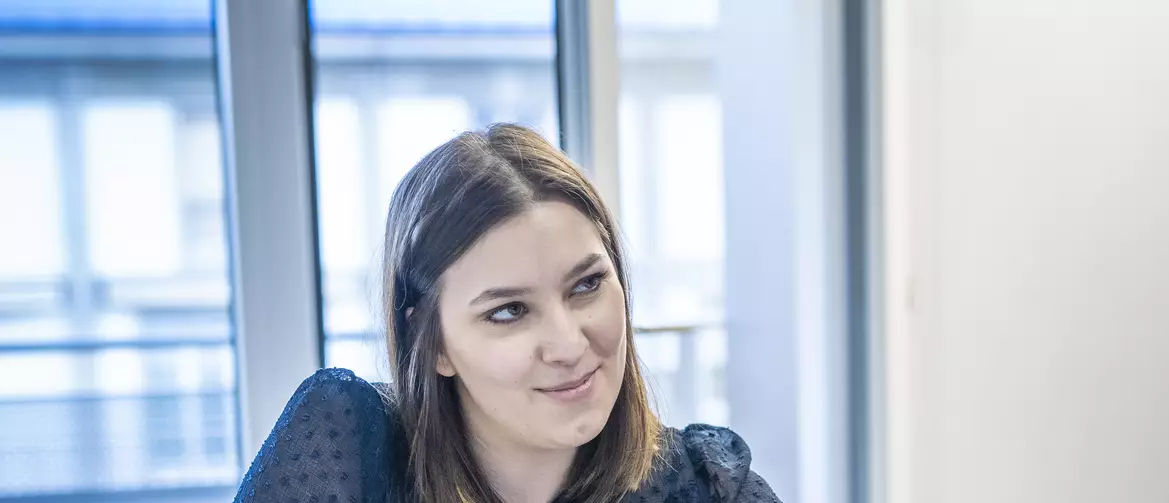 Apprentie employée de commerce prenant des notes dans un agenda en regardant quelqu'un