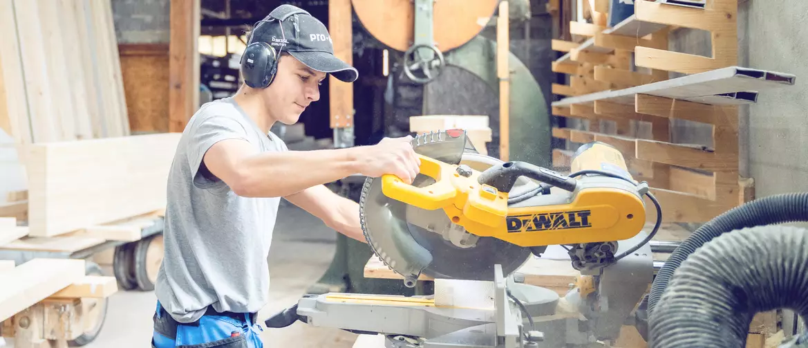 Apprenti charpentier utilisant une machine en atelier
