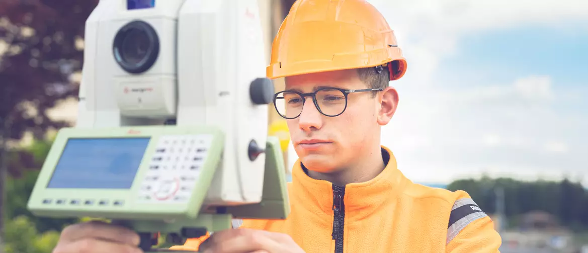 apprenti géomètre prenant des mesures