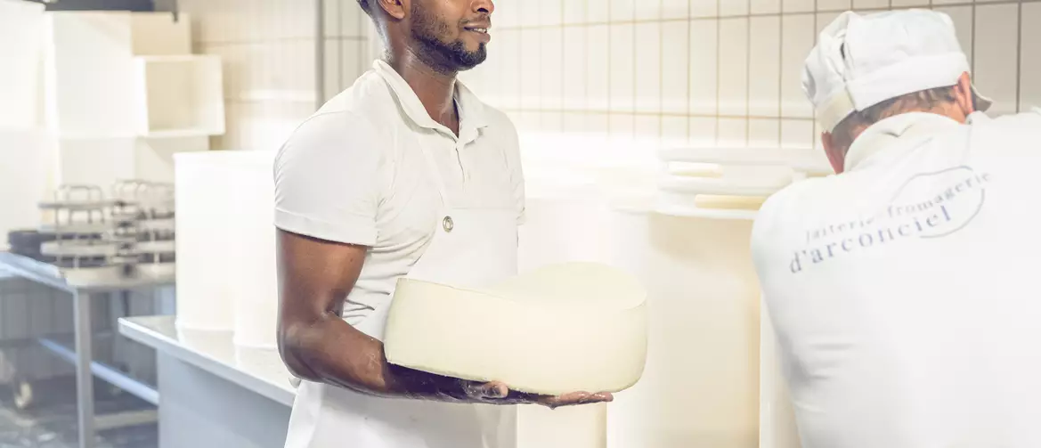 Apprenti fromager et un collègue travaillant