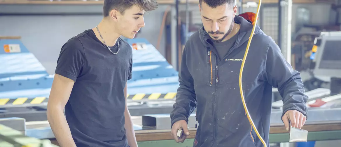 Apprenti ferblantier discutant avec son formateur