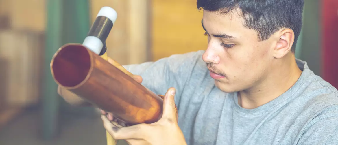 Apprenti ferblantier façonnant un tube